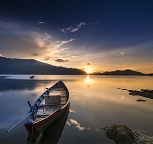 A Lone Boat on a River During Sun Rise With Clear Skies